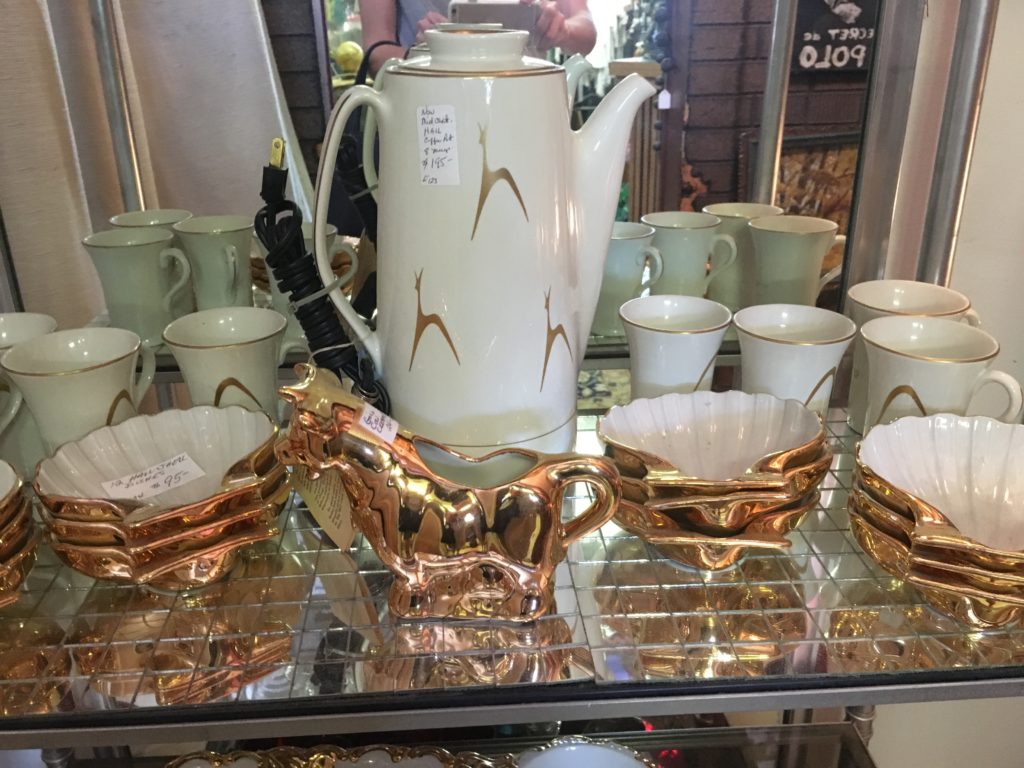 Deer coffee pot and matching cups with gold cow creamer and shell dessert plates that technically don’t go together but really should.